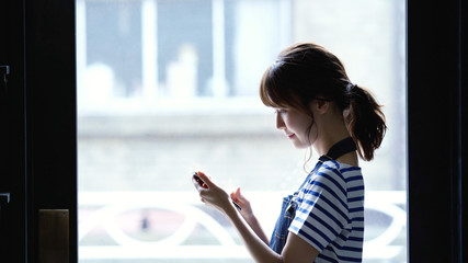 スマホを見る女性 © metamorworks