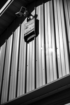 Wooden bat house on white corrugated tin barn