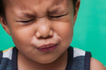 Young boy of 3 years of age showing excruciating pain through facial expression.