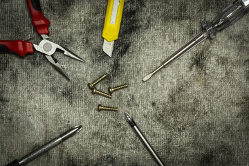 Screw driver,cutter and  pliers on rag background.