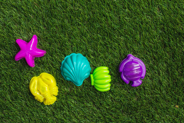 Children's plastic beach toy on grass background.