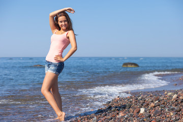 Fototapeta na wymiar young happy girl in summer by the sea