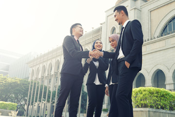 Muslim Asian business people shaking hands with new partner, business co-working teamwork concept....