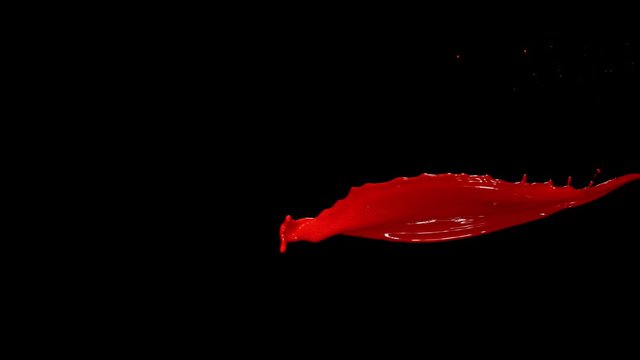 Super slow motion of flying abstract red splash on black background. Filmed on high speed cinema camera, 1000 fps.