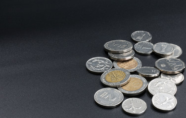 A scattering of coins on a black background