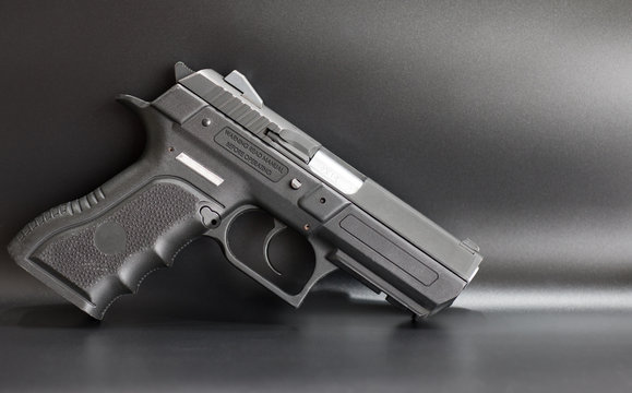 Black 9 mm pistol on a gray background