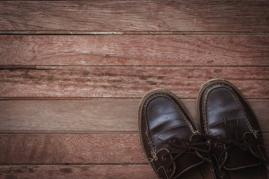 Old brown shoe on wooden floor.