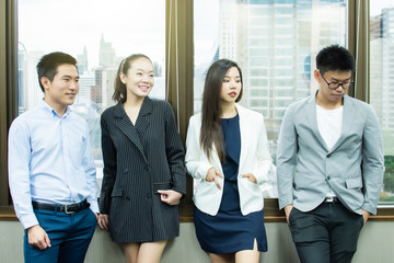 A group of business people standing beside window