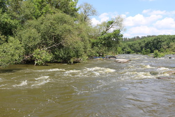 Naklejka na ściany i meble Small rapids on flat rivers attract tourists and travelers in the summer