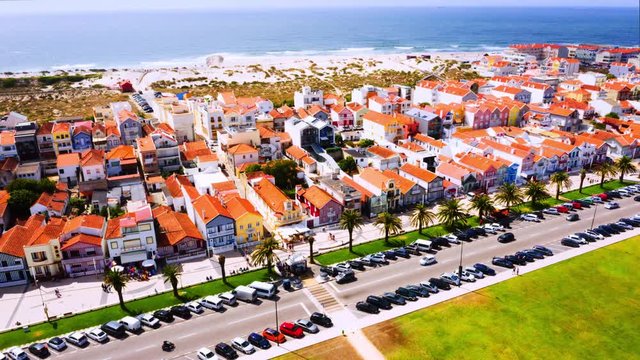 Gafanha da Encarnacao, Portugal. Aerial view of the famous Costa Nova colorful houses in Aveiro, Portugal. Time-lapse from above with car traffic and sea at the background