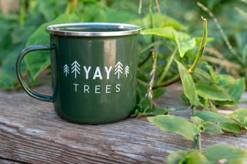 Enamel Mug Green on wood , with green vines around it.