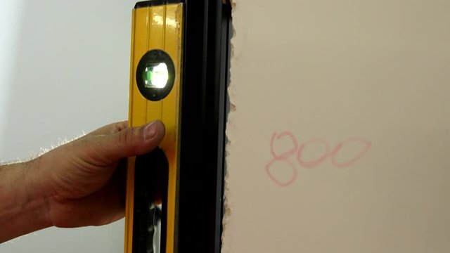 in the hand of the line level of the Clinometer bubbles to measure the evenness of the wall. rays of light enter the chamber. slow motion. close up