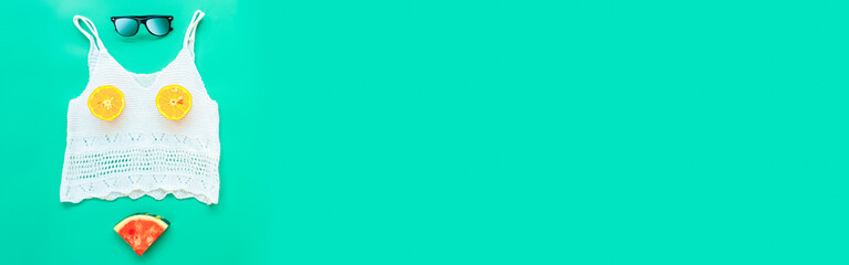 Woman summer clothes concept from Women's Clothing, Sunglasses and orange fruit cut in half, flat lay on green background pastel color for Advertising sale products and Website where place banner ads.