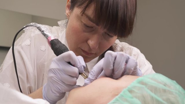 Cosmetic procedure of lips permanent make-up. Female cosmetologist performs dermapigmentation procedure in the beauty salon. Beauty concept