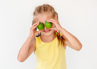 Little girl with fresh lime fruits