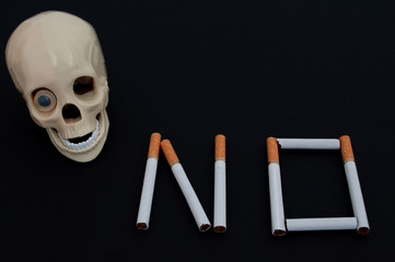 skull with cigarettes on black background