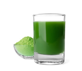 Glass of wheat grass juice and bowl with powder on white background