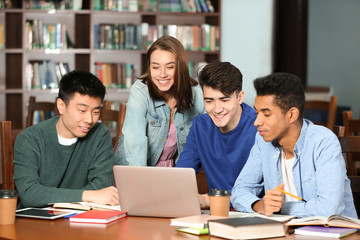 Group of students studying at table in library