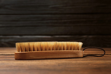 Shoe brush on wooden table. Footwear care item