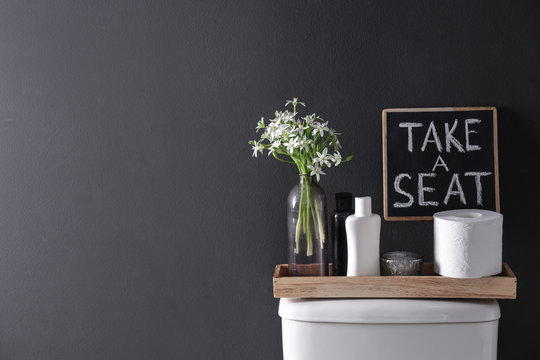 Decor Elements, Necessities And Toilet Bowl Near Black Wall, Space For Text. Bathroom Interior