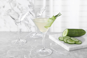 Glass of tasty cucumber martini on grey marble table
