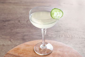 Glass of tasty cucumber martini on wooden table