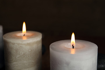 Obraz na płótnie Canvas Burning aromatic candles on dark background, closeup