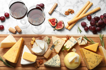 Flat lay composition with different types of delicious cheese on marble table