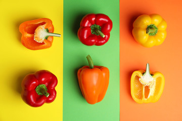 Flat lay composition with ripe bell peppers on color background