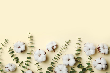 Flat lay composition with cotton flowers on yellow background. Space for text