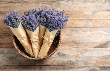 Fresh lavender flowers in basket on wooden table, top view. Space for text