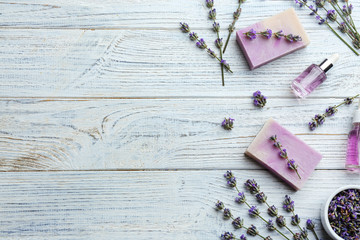 Obraz premium Flat lay composition of handmade soap bars with lavender flowers on white wooden background. Space for text