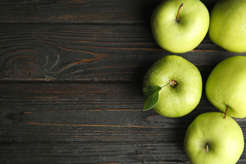 Flat lay composition of fresh ripe green apples on black wooden table, space for text