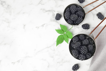 Fototapeta na wymiar Flat lay composition with tasty ripe blackberries and space for text on marble table