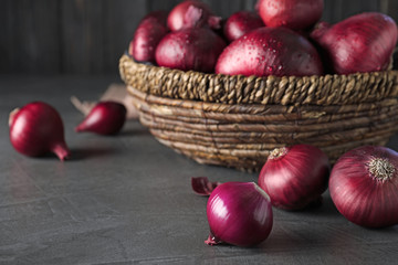 Fresh whole red onion bulbs on grey table. Space for text