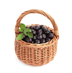 Wicker basket with fresh acai berries on white background
