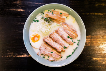 Top view of Ramen Cream Pork Bone Soup (Tonkotsu Ramen) with Chashu Pork, Scallion, Sprout, Onion, Menma and Dried Seaweed and boiled egg.