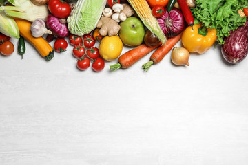 Different fresh vegetables on light table, flat lay. Space for text