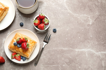 Obraz na płótnie Canvas Fresh delicious puff pastry with sweet berries on grey marble table, flat lay. Space for text