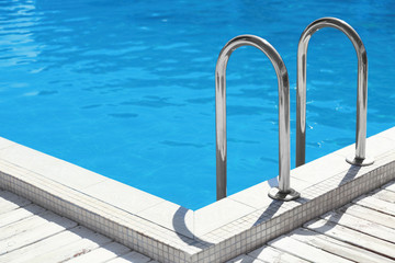 Fototapeta na wymiar Modern swimming pool with step ladder outdoors