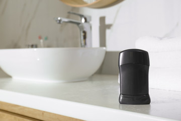 Deodorant container on light countertop in bathroom