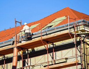 Naklejka premium Roofer works on the roof of an old building
