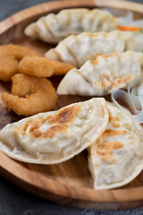 Close-up of fried potstickers and king shrimps in panko breading, selective focus, vertical shot