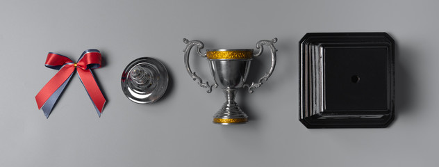 Set of Champion silver trophy on gray background,top view