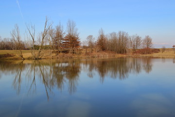 Fototapeta na wymiar Small lake in the countryside and winter colors