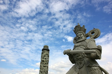 Fototapeta na wymiar Chinese god stone carving with blue sky white cloud in Thai land.