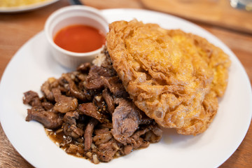Fried lamb meat with garlic on the hot rice and omeleted egg