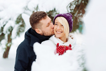 Handsome young couple having time outside, winter walking, hugging and kissing