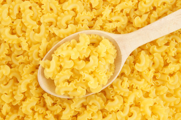 Macaroni background with wooden spoon