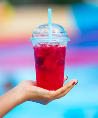 Red cocktail in the hands of a girl